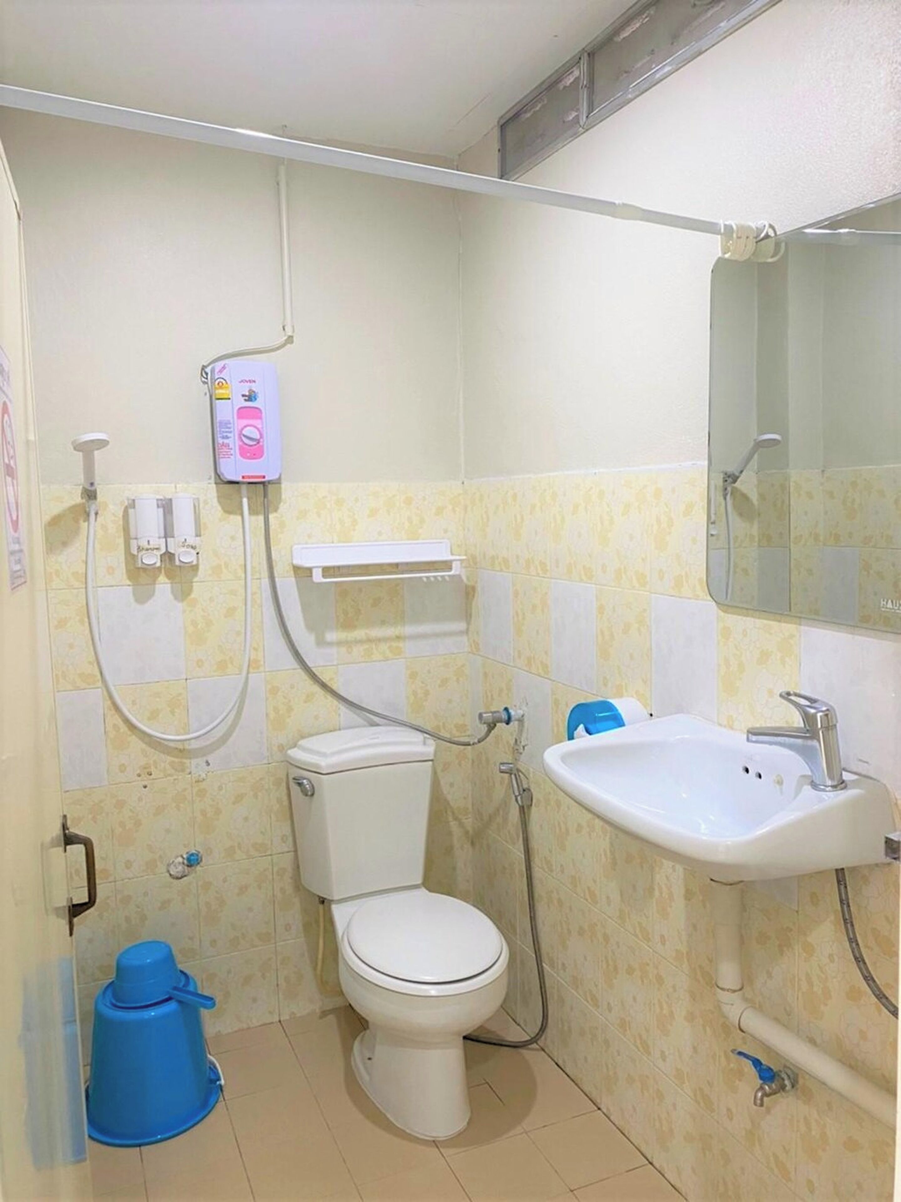 Een compacte badkamer met toilet, wastafel en douche.