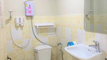Een compacte badkamer met toilet, wastafel en douche.