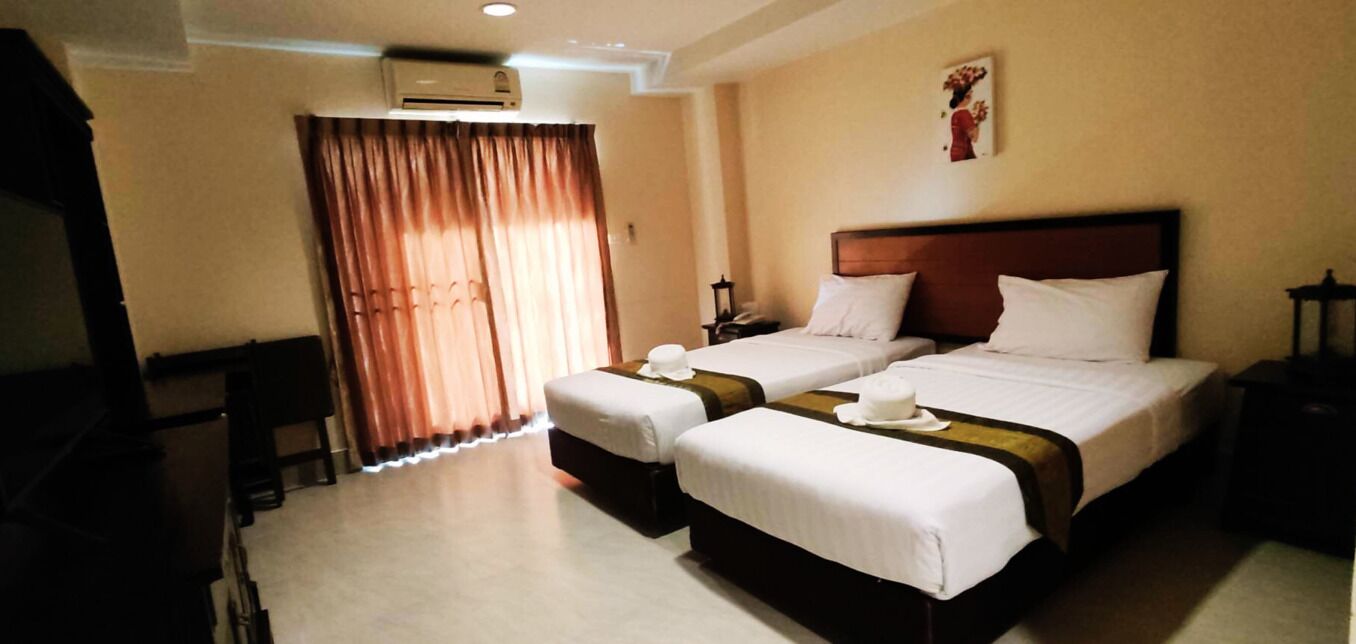 Habitació d'hotel amb dos llits, una taula i una cadira.