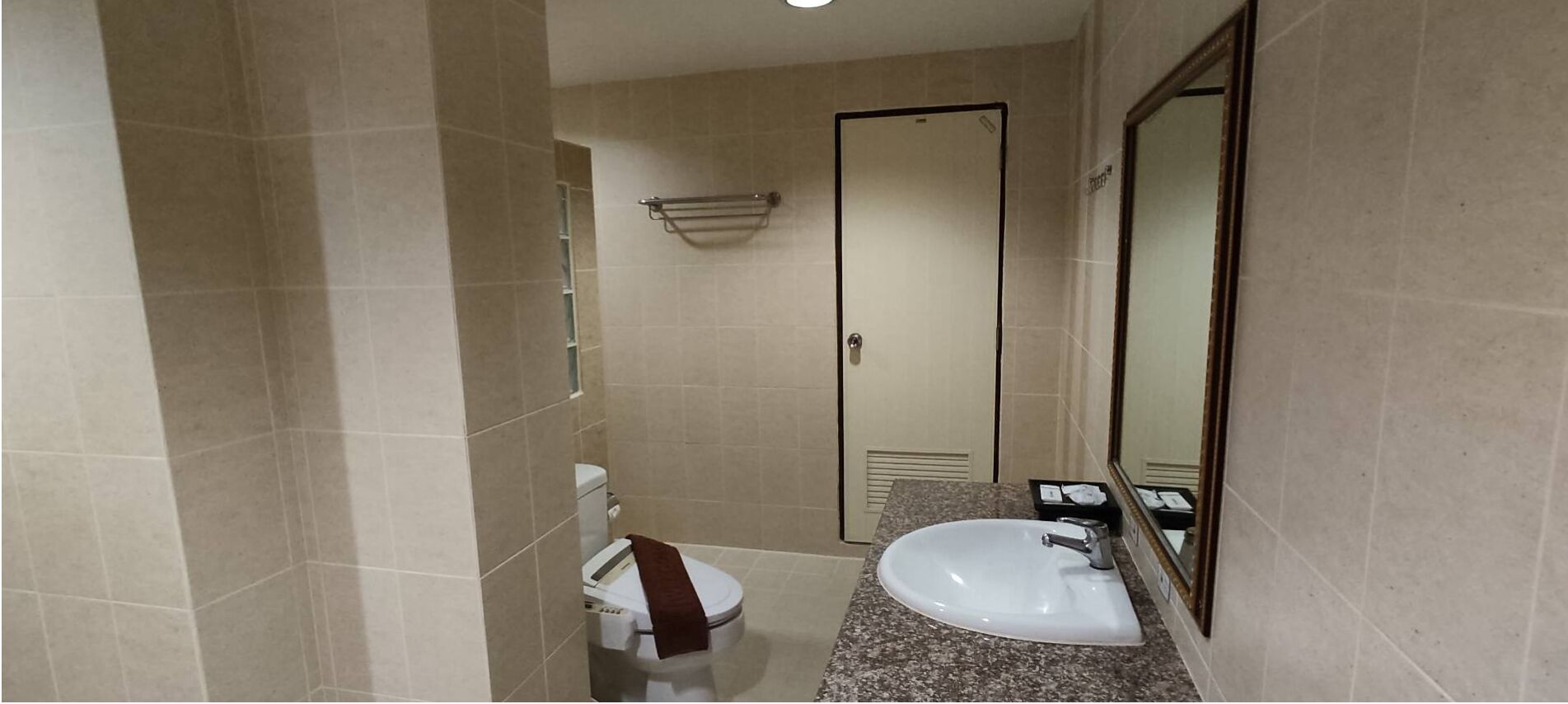 A bathroom with a toilet, sink, and mirror.