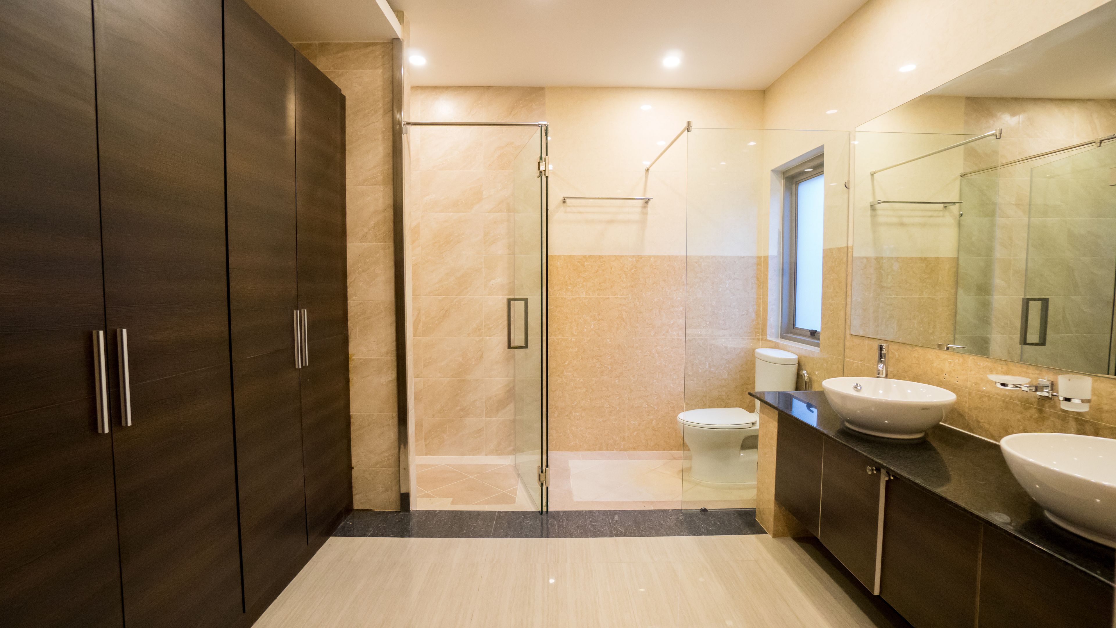 A modern bathroom with a walk-in shower, a toilet, and a sink.