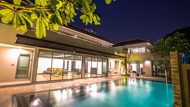 A modern house with a swimming pool, large windows, and outdoor furniture. - Villa Navin Resort (Pattaya)