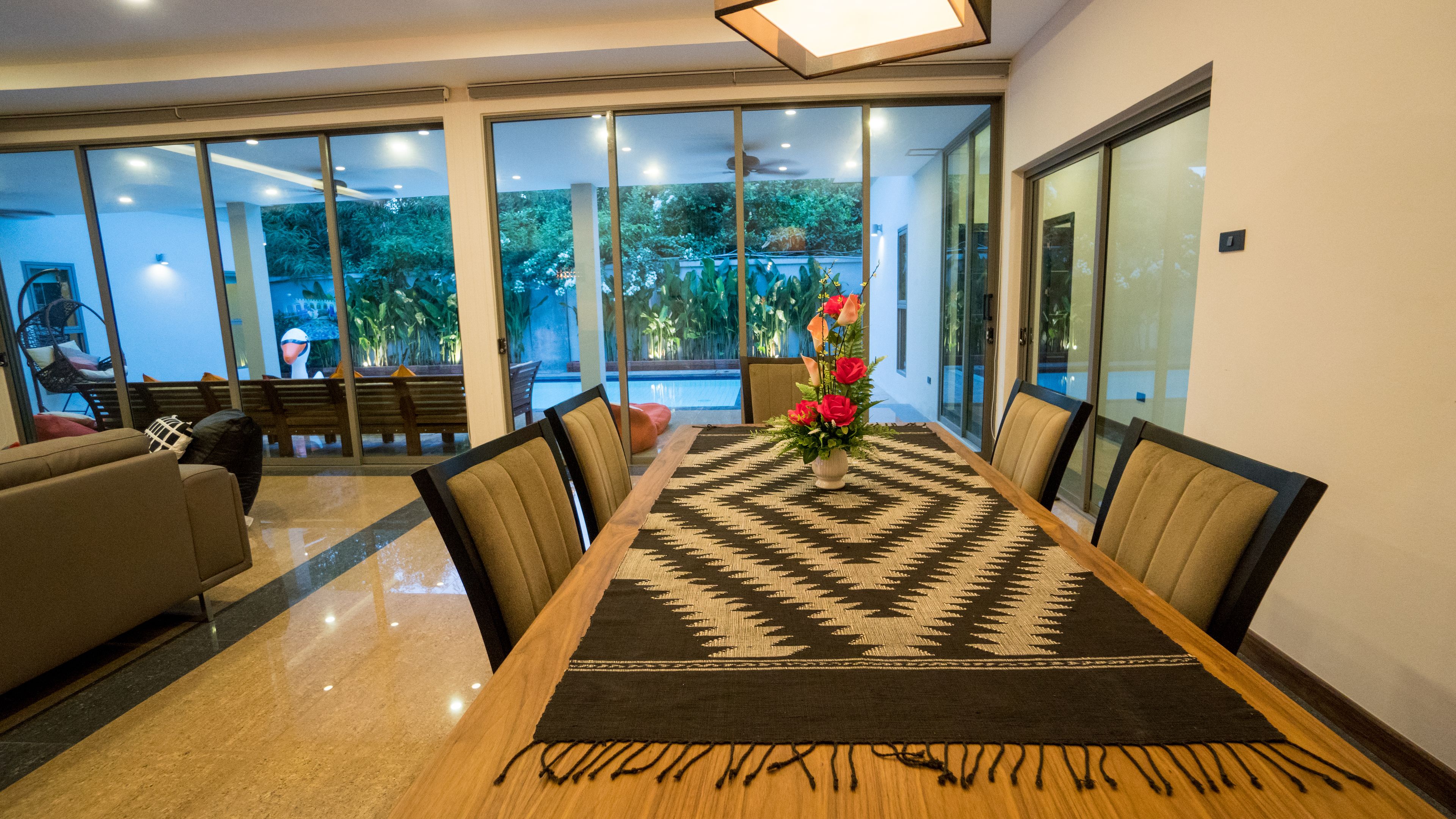 Un espace repas comprenant une longue table, des chaises et un tapis décoratif.