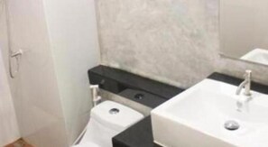 Un bagno con il water, un lavandino e uno specchio.
