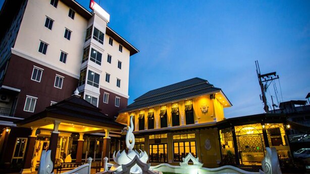 A hotel with a traditional architectural design, featuring a prominent entrance with a decorative gate and a well-lit facade. - Madina Hotel (Rayong)