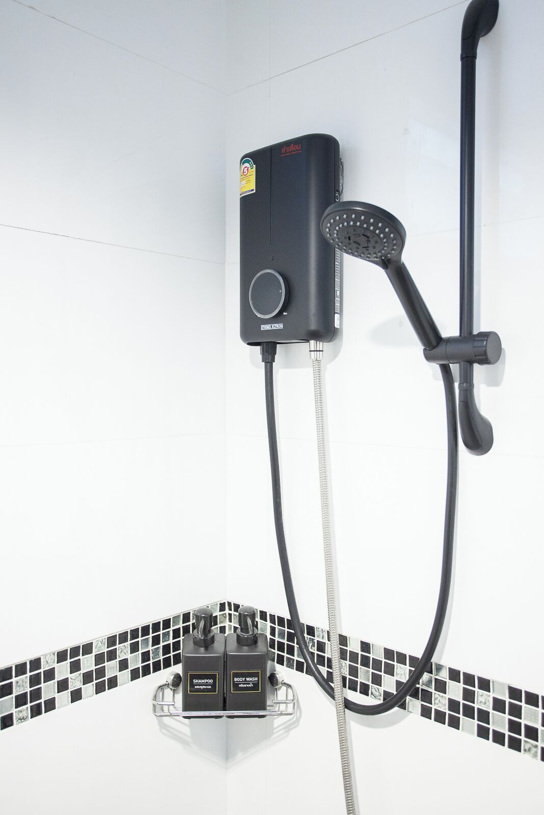 A modern bathroom with a built-in shower unit, a handheld showerhead, and a wall-mounted control panel.