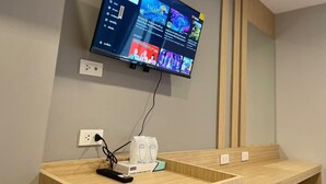 Televisor de pantalla plana montado en la pared mostrando la interfaz de una plataforma de streaming.