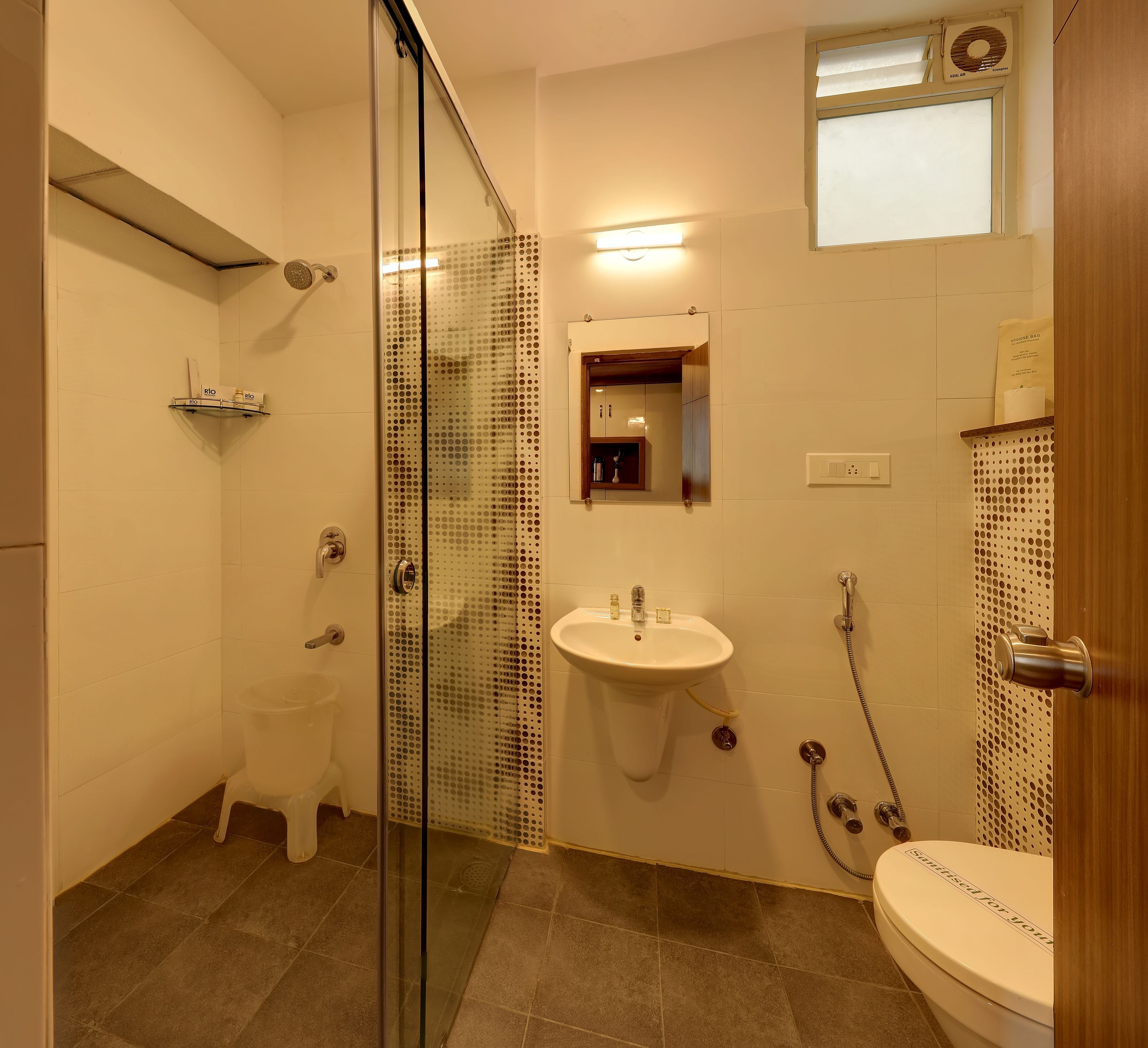 A modern bathroom with a glass shower enclosure, a sink, and a toilet.