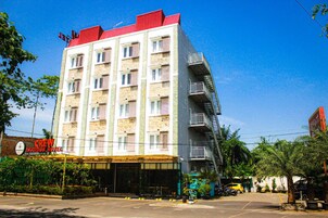 Un hotel de varios pisos con tejado rojo, balcones y un letrero que dice Crew Express Hotel.