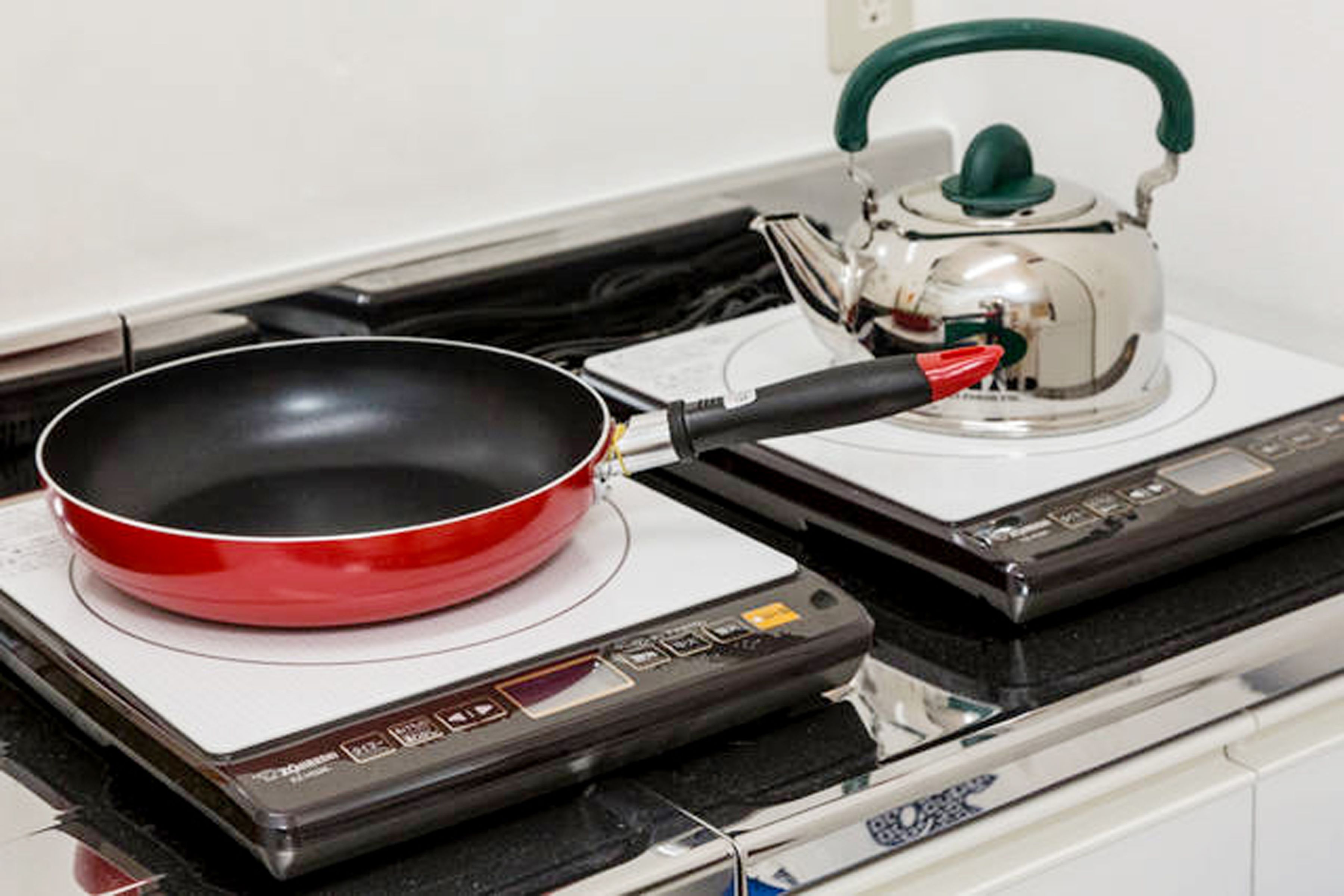 Une cuisinière avec une poêle et une bouilloire.