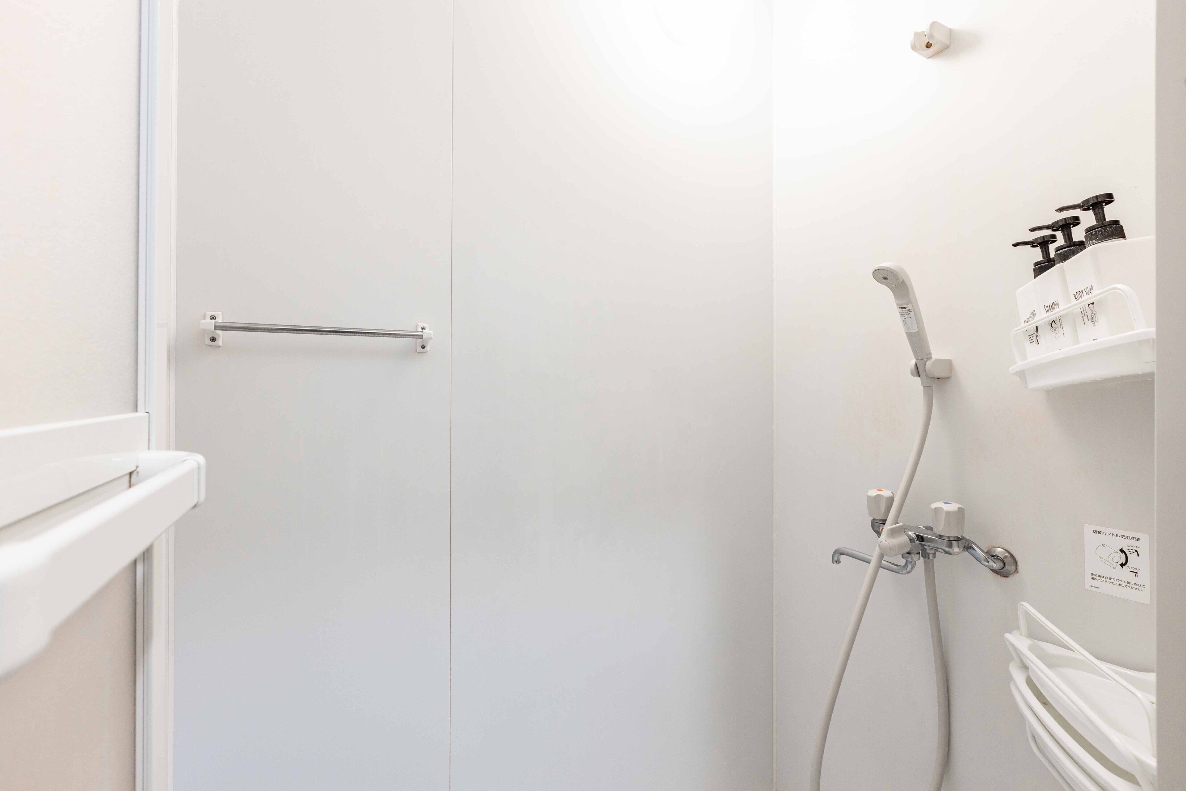 A bathroom with a shower, toilet, and towel rack.