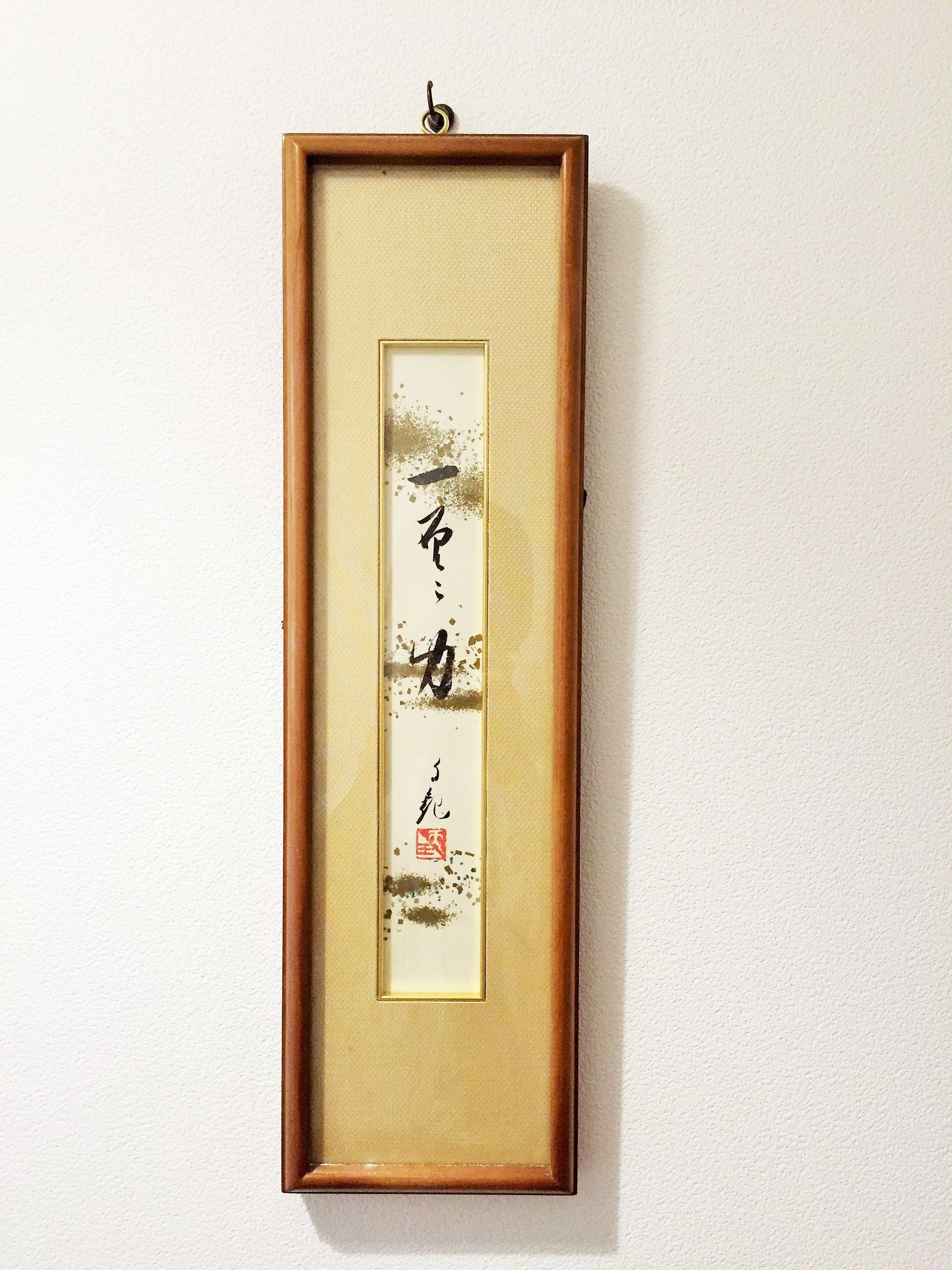 A framed calligraphy piece on a wall.