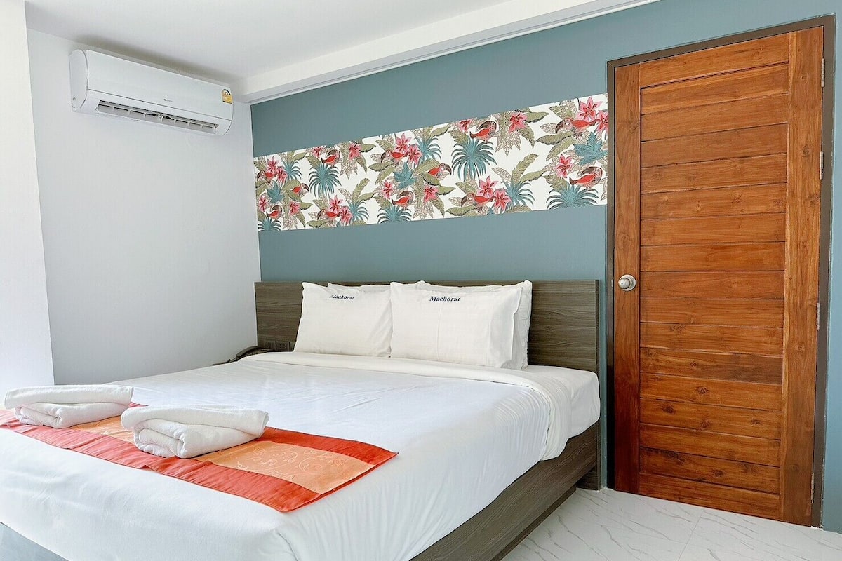 A neatly made bed with white linens and two pillows labeled "Nachoat".