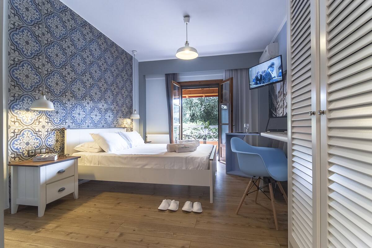 Una camera da letto moderna con un letto, un comodino, una lampada e una scrivania con una sedia.
