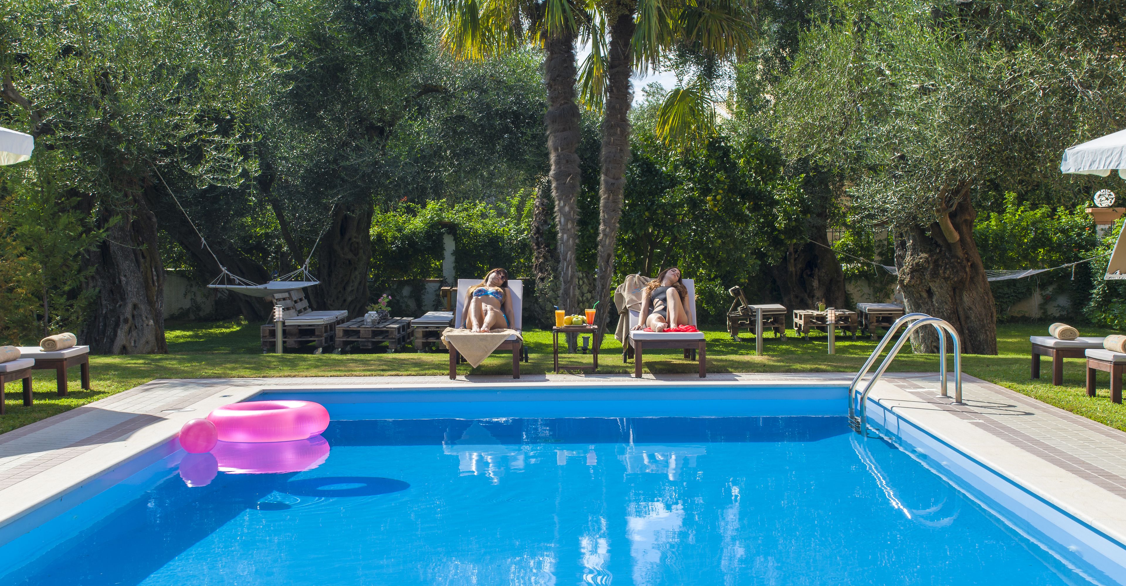 A swimming pool with lounge chairs and a palm tree in the background.