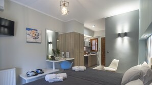 A modern hotel room with a large bed, a desk with a computer, a chair, and a mirror. - Ano Aparthotel (Corfu)