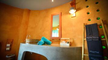 Bathroom features a curved wall, large mirror, and modern sink under a window.