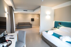 Una habitación de hotel moderna con cama, escritorio, sofá y televisión.