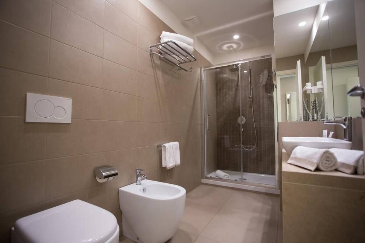 Ein modernes Badezimmer mit einer Bidet, einer Dusche und einem Waschbecken.
