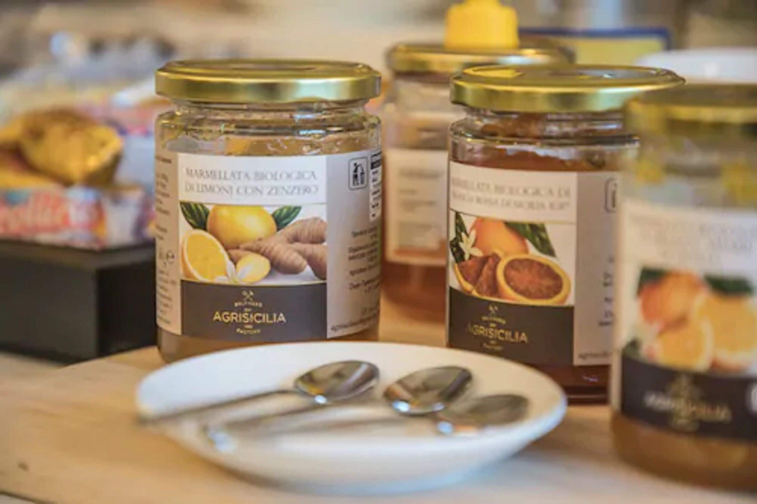 Jars of marmalade on a table with spoons.
