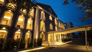 A multi-story hotel with illuminated balconies and a covered entrance.