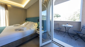 A hotel room with a bed, a bedside table, a phone, and a view of the balcony.