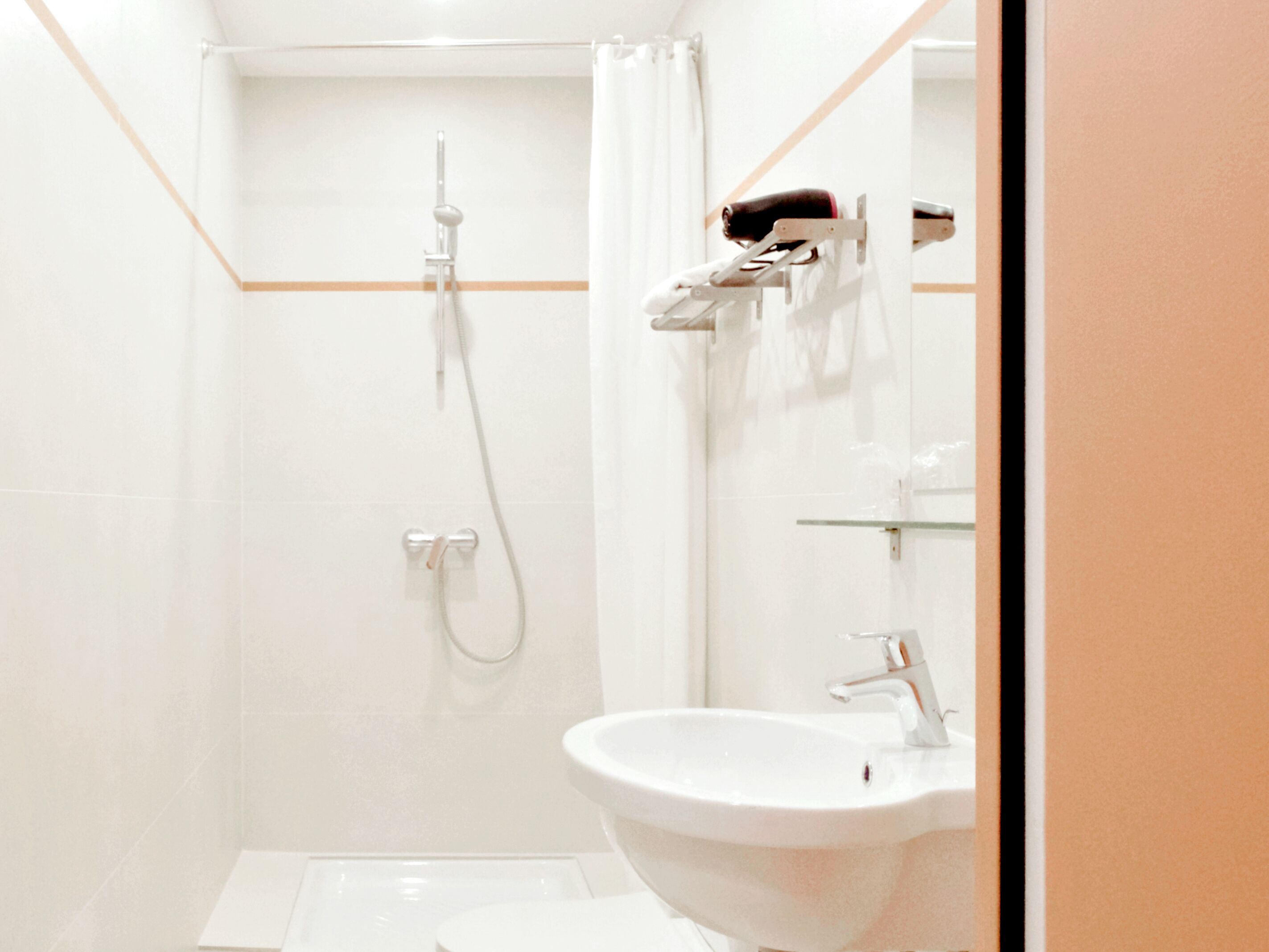 Une salle de bain moderne équipée d’une douche, d’un lavabo et d’un porte-serviettes.