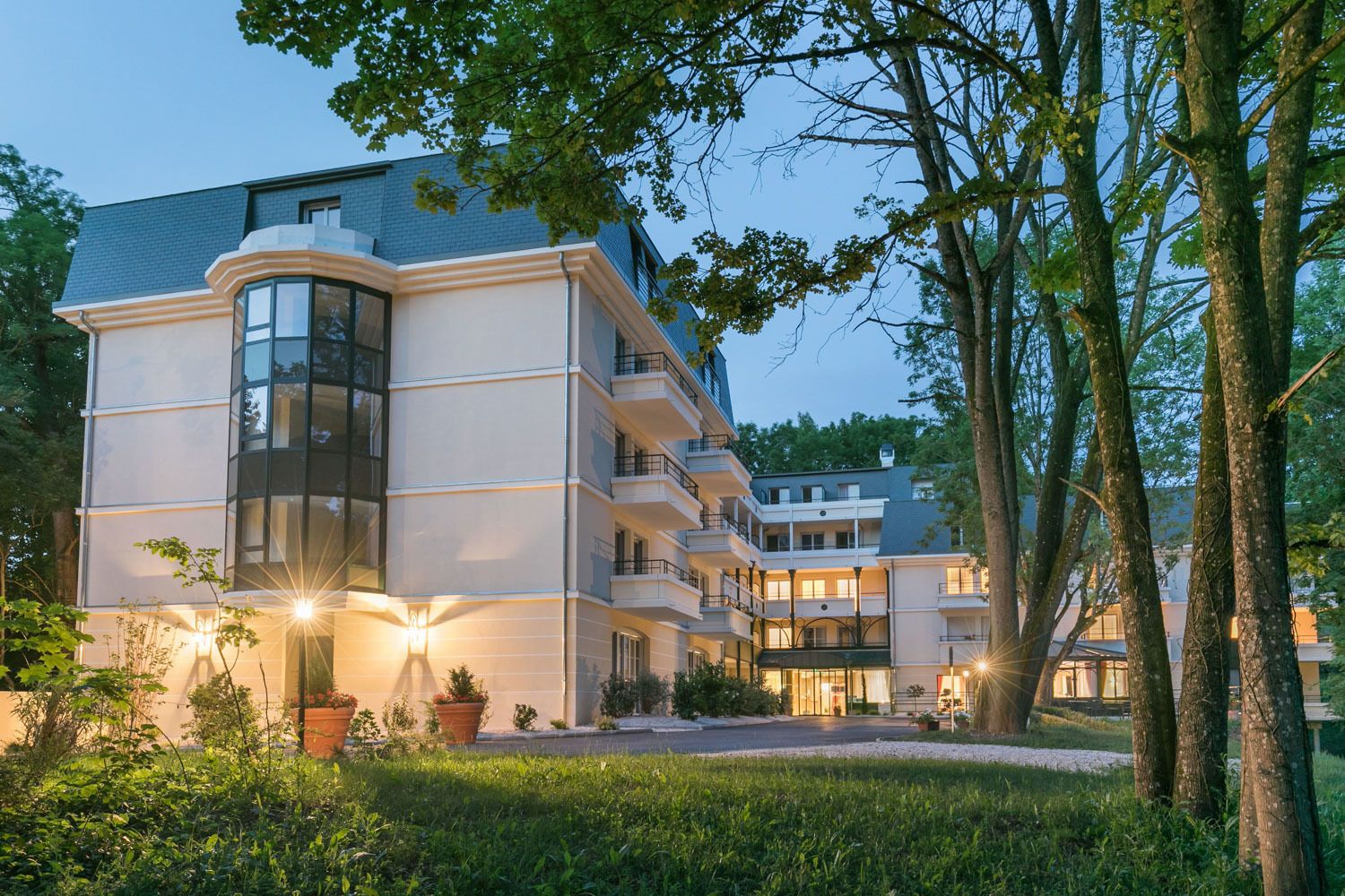 A multi-story hotel with a modern design, featuring balconies and large windows.