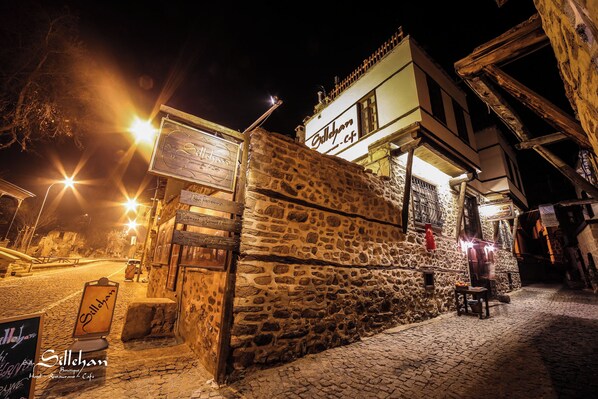 A stone building with a sign reading "Sillachan Hotel Restaurant & Cafe" at night.