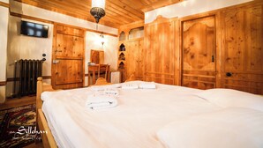 Una habitación de madera con una cama, un televisor y un escritorio.