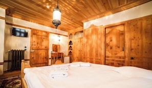 A wooden room with a bed, a television, and a desk. - Sillehan Boutique Hotel (Konya)
