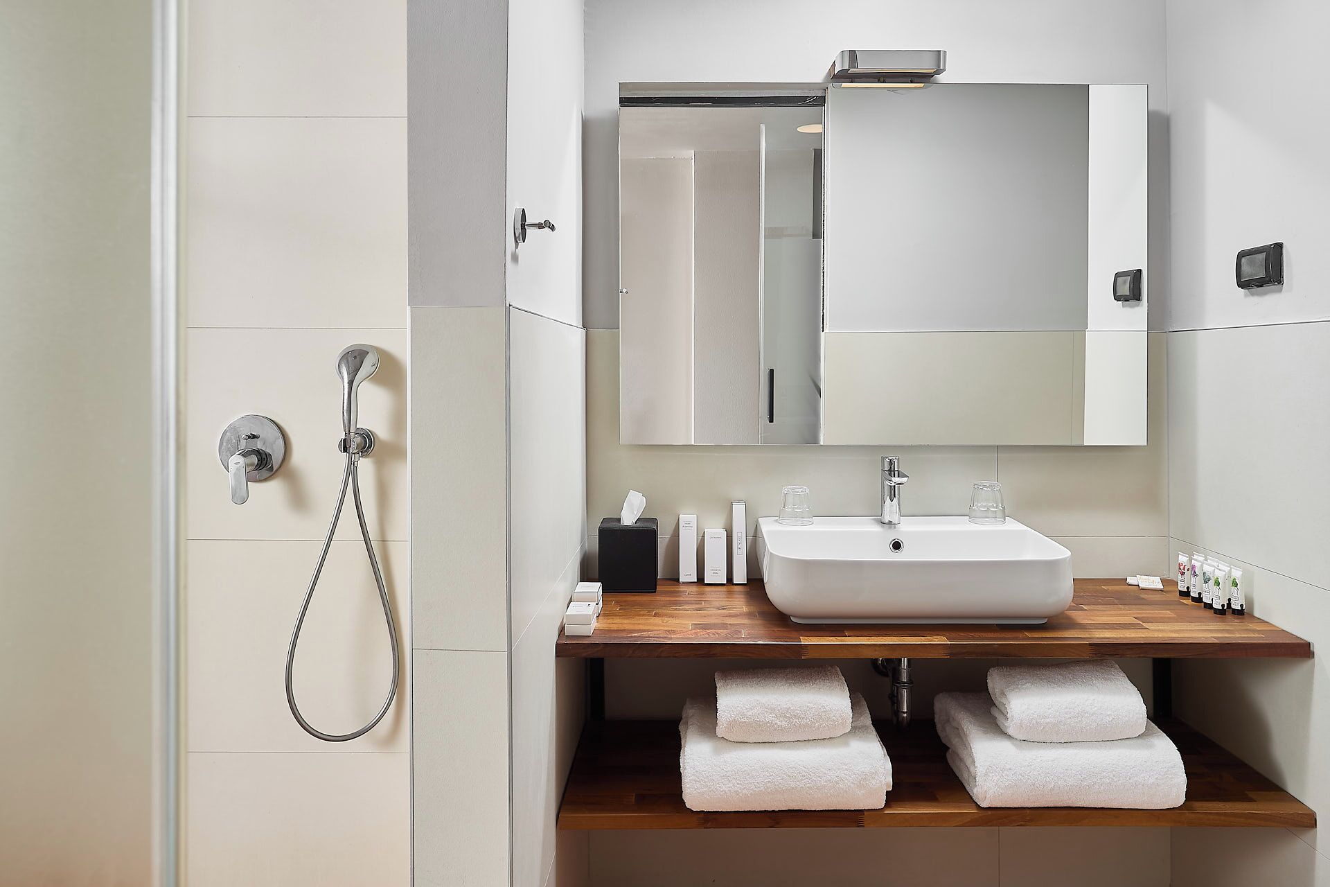 A modern bathroom with a white sink, mirror, and towel rack.