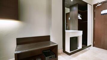 A modern bathroom with a large mirror, a sink, and a dark wood vanity.