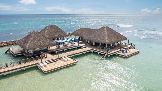 A resort with thatched-roof overwater bungalows, a wooden deck, and a pool area. - Hotel Casa Hemingway (Guayacanes)
