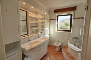 Une salle de bain moderne avec un grand lavabo, un bidet et une baignoire.