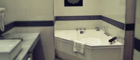Un baño moderno con una bañera independiente, un perchero para toallas y un adorno de pared decorativo.