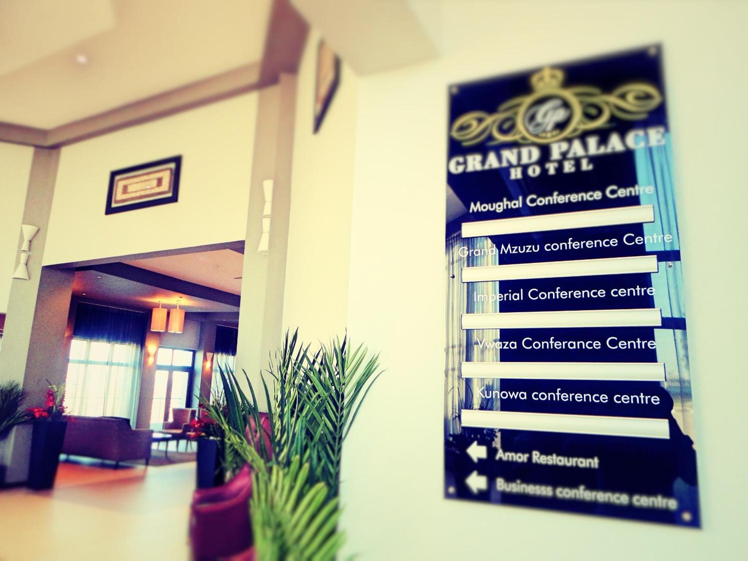 Un cartel que enumera varios centros de convenciones y un restaurante en el Hotel Grand Palace.
