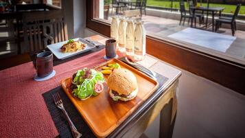 A dining table with a meal, a bottle of water, and a menu.