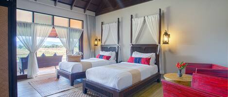 A bedroom with two beds, a red dresser, and a view of the outdoors.