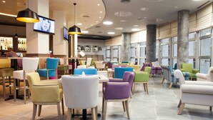 Un interior moderno con una zona de bar, diversas opciones de asientos y ventanas amplias.