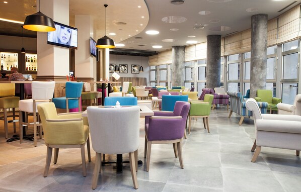 A modern interior with a bar area, multiple seating options, and large windows. - Atera Business Suites (Belgrade)
