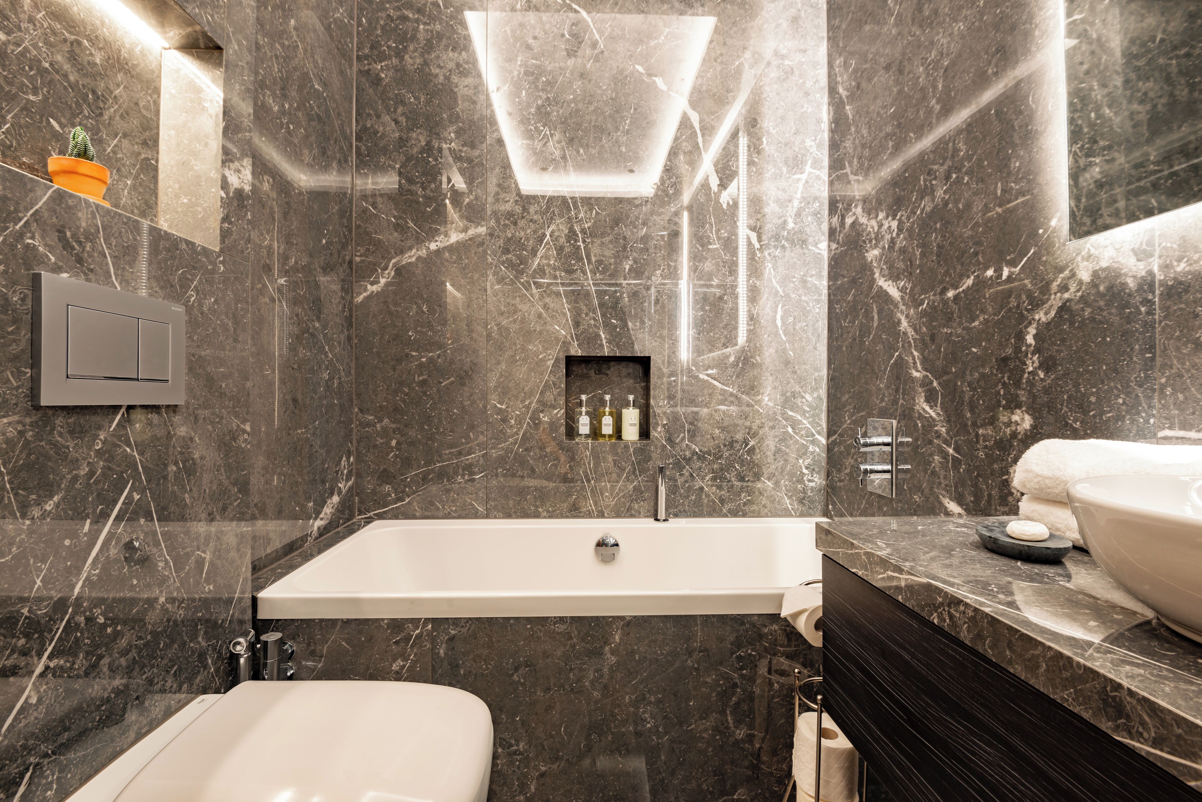 A modern bathroom with a large bathtub, a toilet, and a vanity with a sink.