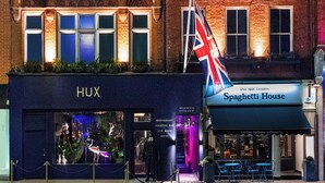 A building with a 'HUX' sign, a 'Spaghetti House' restaurant, and a British flag.