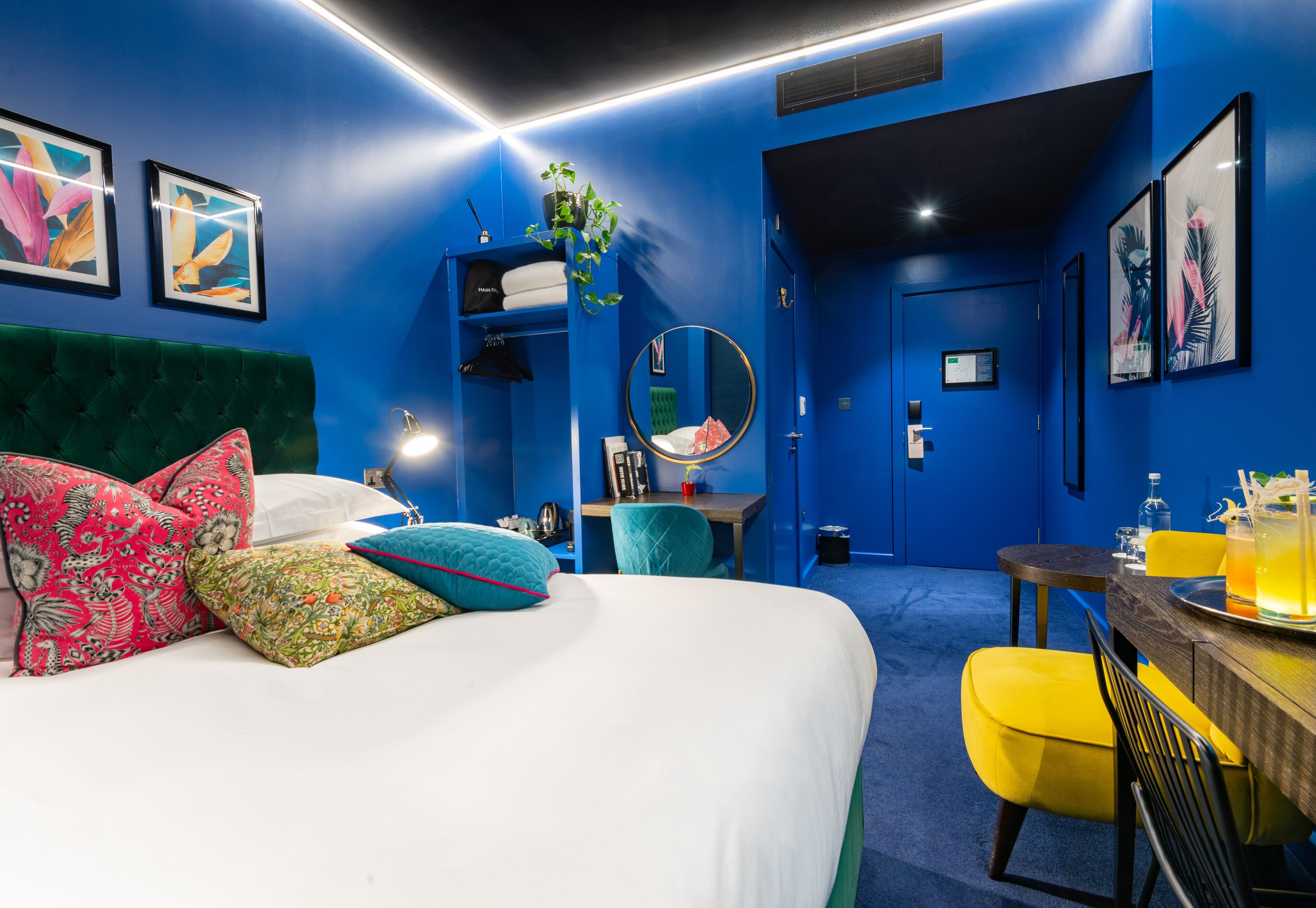 A room with a bed, a desk, a chair, and a mirror.
