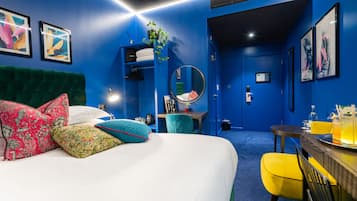 A room with a bed, a desk, a chair, and a mirror.