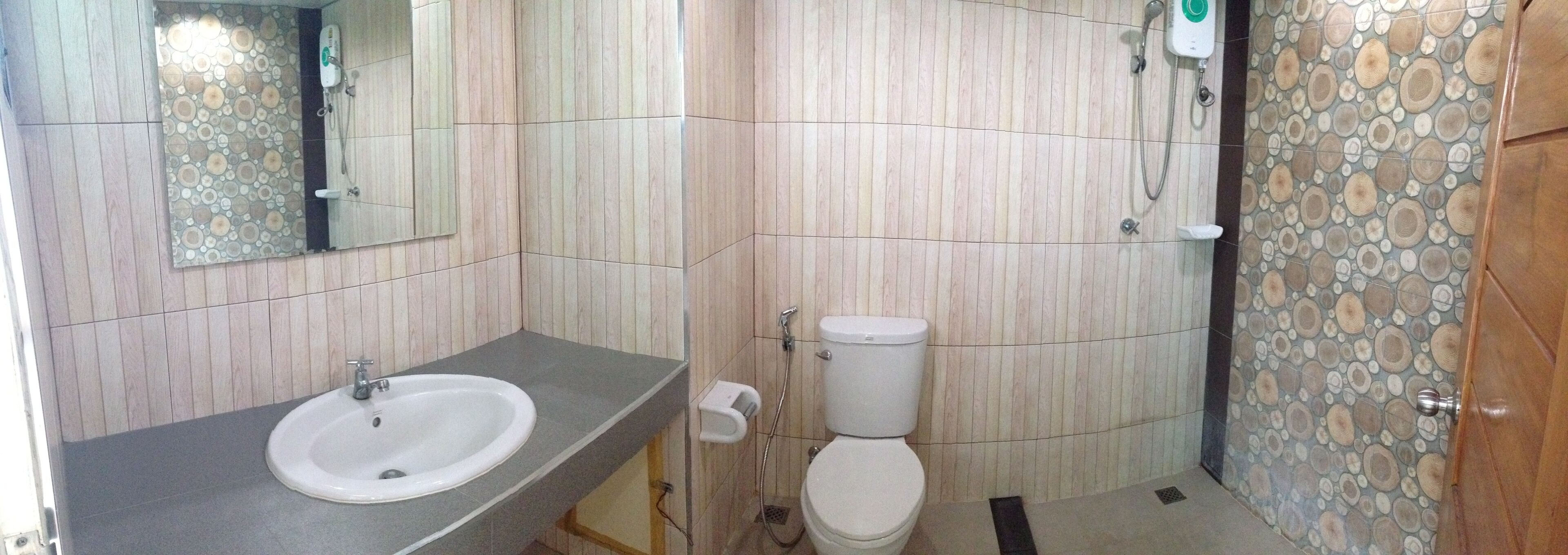 A bathroom with a sink, toilet, and a mirror.