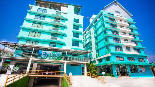 Un hôtel à plusieurs étages, dont l’entrée est marquée par une enseigne bien visible indiquant « EDEN GARDEN ».