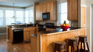 Una cocina con armarios de madera, una isla central y un microondas.