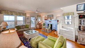 A spacious living room with a sofa, armchairs, and a fireplace. - Bonnie Doon 2 Bedroom Holiday Home By Bald Head Island (Bald Head Island)