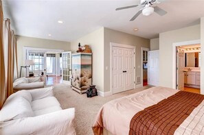 A bedroom with a bed, a sofa, a wardrobe, and a ceiling fan. - Bogan s on the Beach 4 Bedroom Holiday Home By Bald Head Island (Bald Head Island)